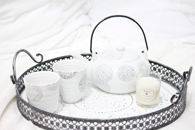 čajník, dva šálky a svíčka na romantickém podnose pro romantickou atmosféru