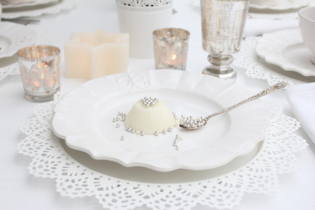 prostřený stůl s romantickým bílým talířem a lžičkou plnou perel