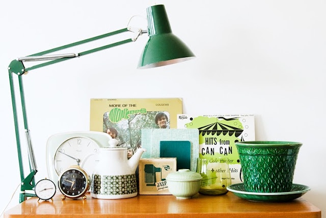 dekorace v zeleném odstínu - lampa, hrnek, čajník, hodiny na dřevěném stole