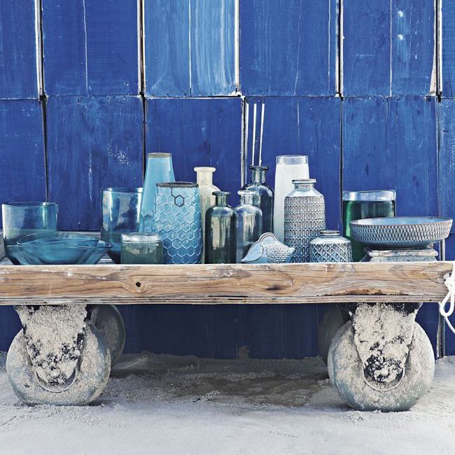 vázy v modré barvě na dřevem vozíku na kolečkách