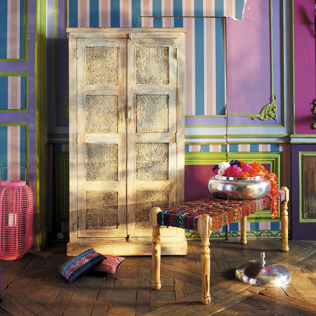 dřevěná skříň v barevné místnosti s pruhovanými tapetami