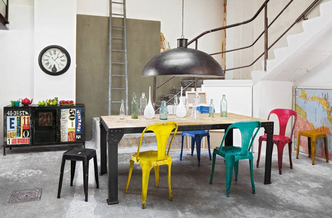 barevné kovové jídelní židle za jídelním stolem v industriálním stylu