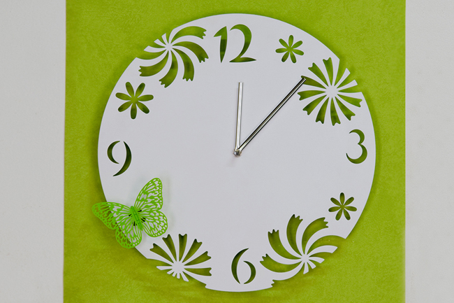 dekorativní hodiny se zeleným motýlkem
